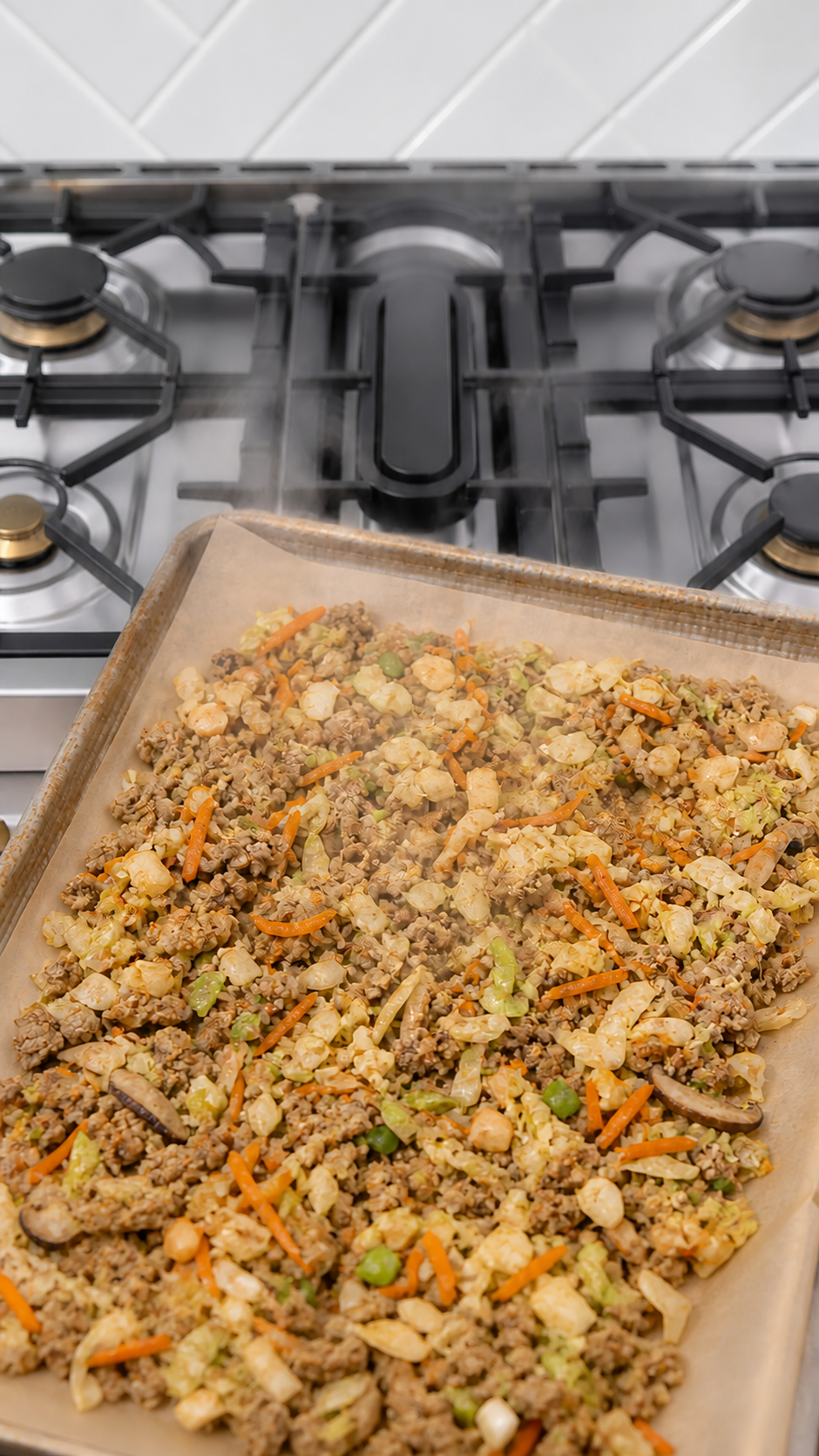 Cooked pork and vegetable egg roll filling draining and cooling on a rimmed baking sheet.