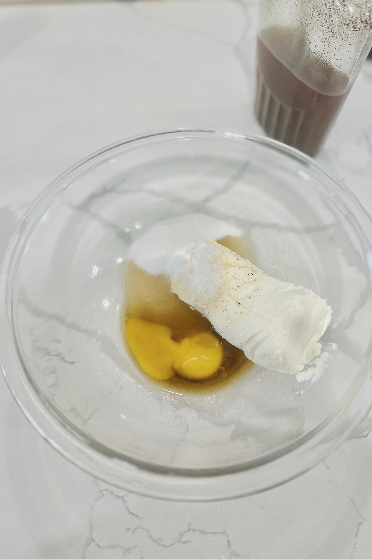 Cream cheese, egg yolks, sugar, and vanilla in a glass bowl for kolache filling.