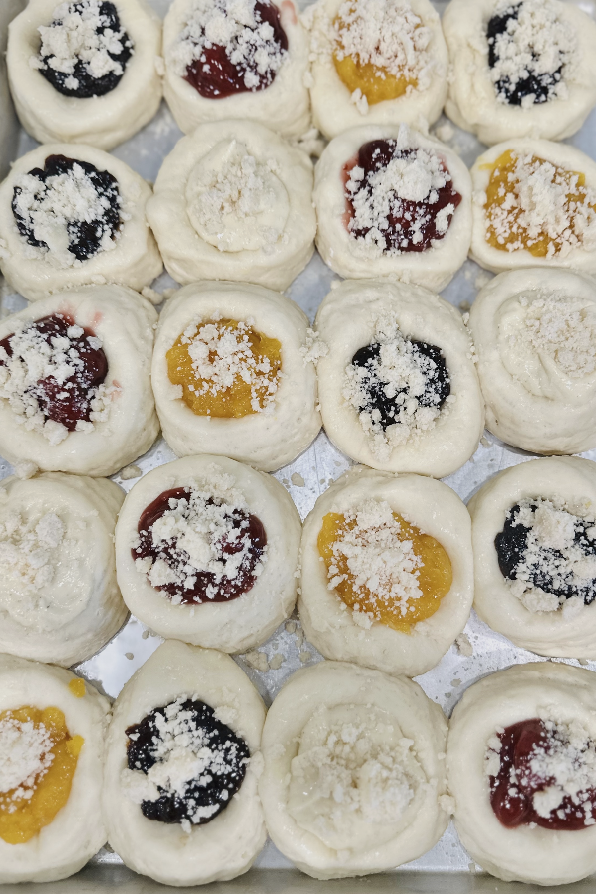 Posypka sprinkled over assorted filled kolaches before baking.