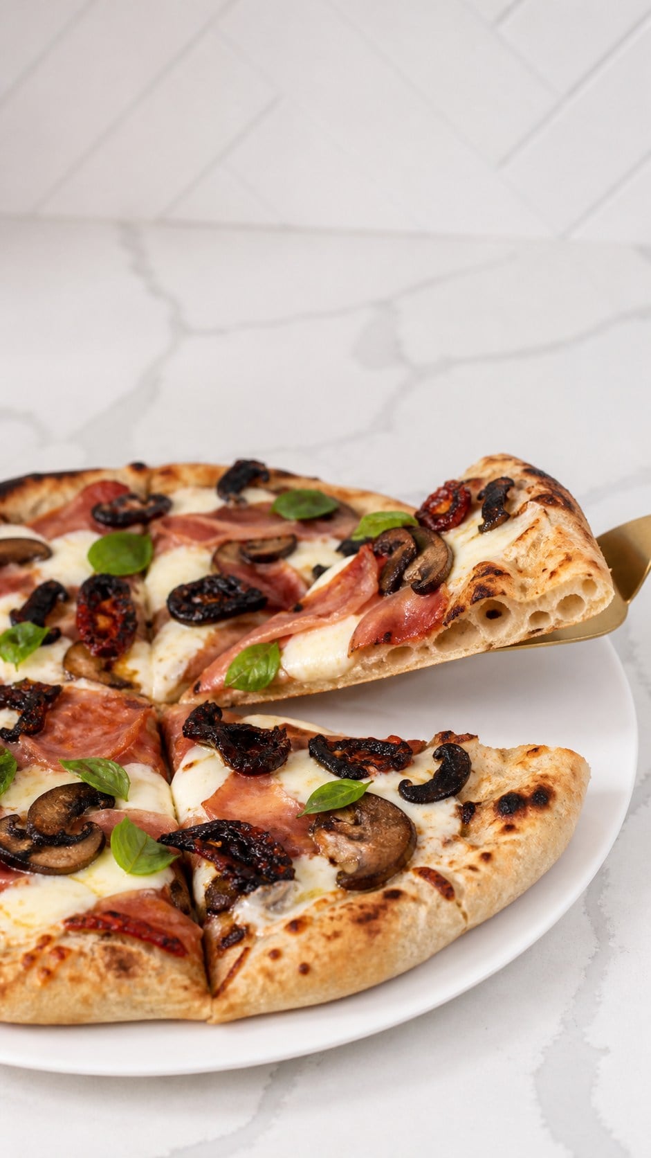 Slice of wood-fired pizza lifted to show its airy chewy crust and blistered rim.