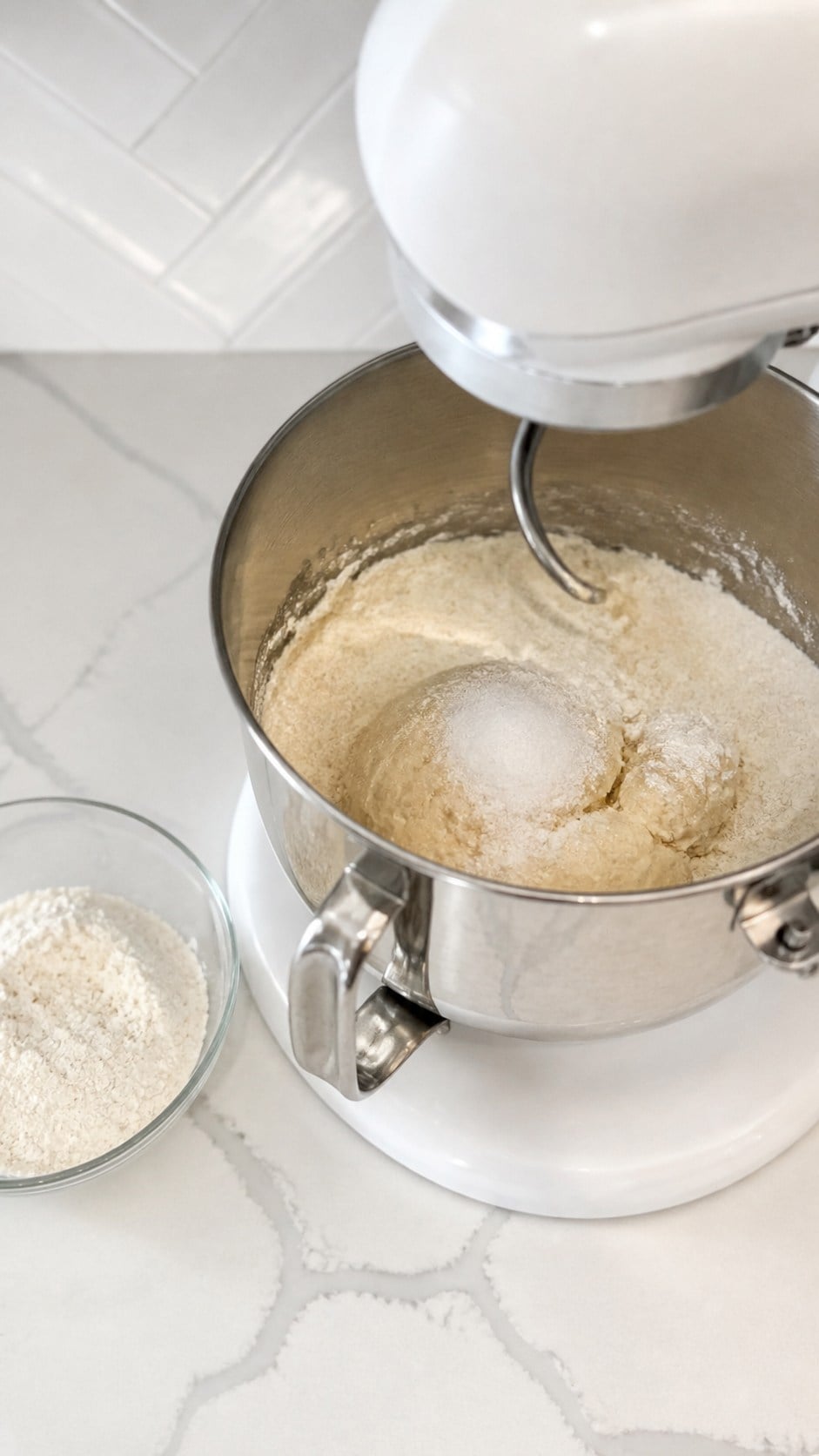 Flour and kosher salt being added to rough pizza dough.