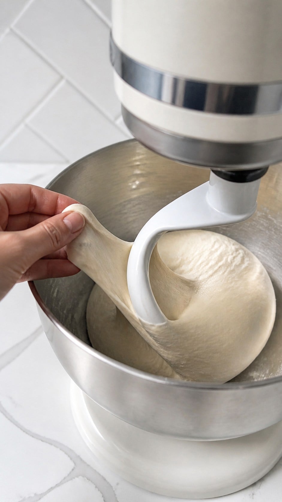 Smooth elastic pizza dough stretching from a dough hook.