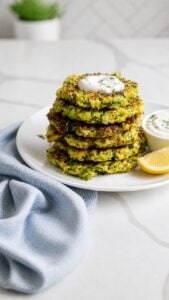 Stack of crispy zucchini fritters with deeply browned edges and visible zucchini shreds.