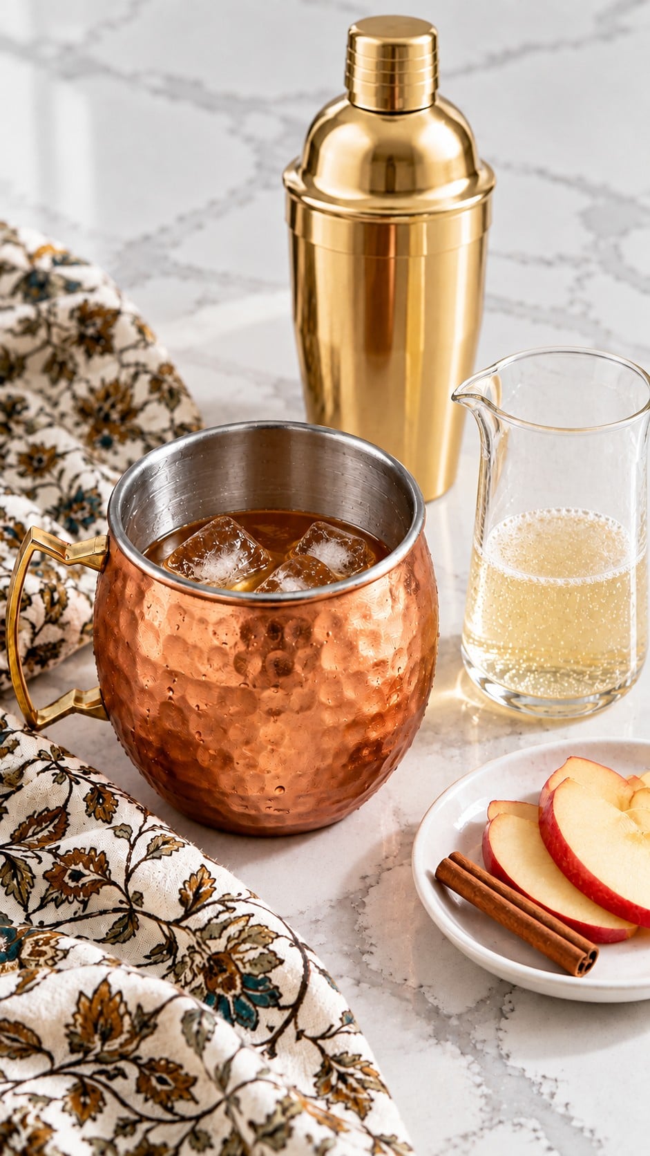 Cider cocktail base in a copper mug beside ginger beer ready to add