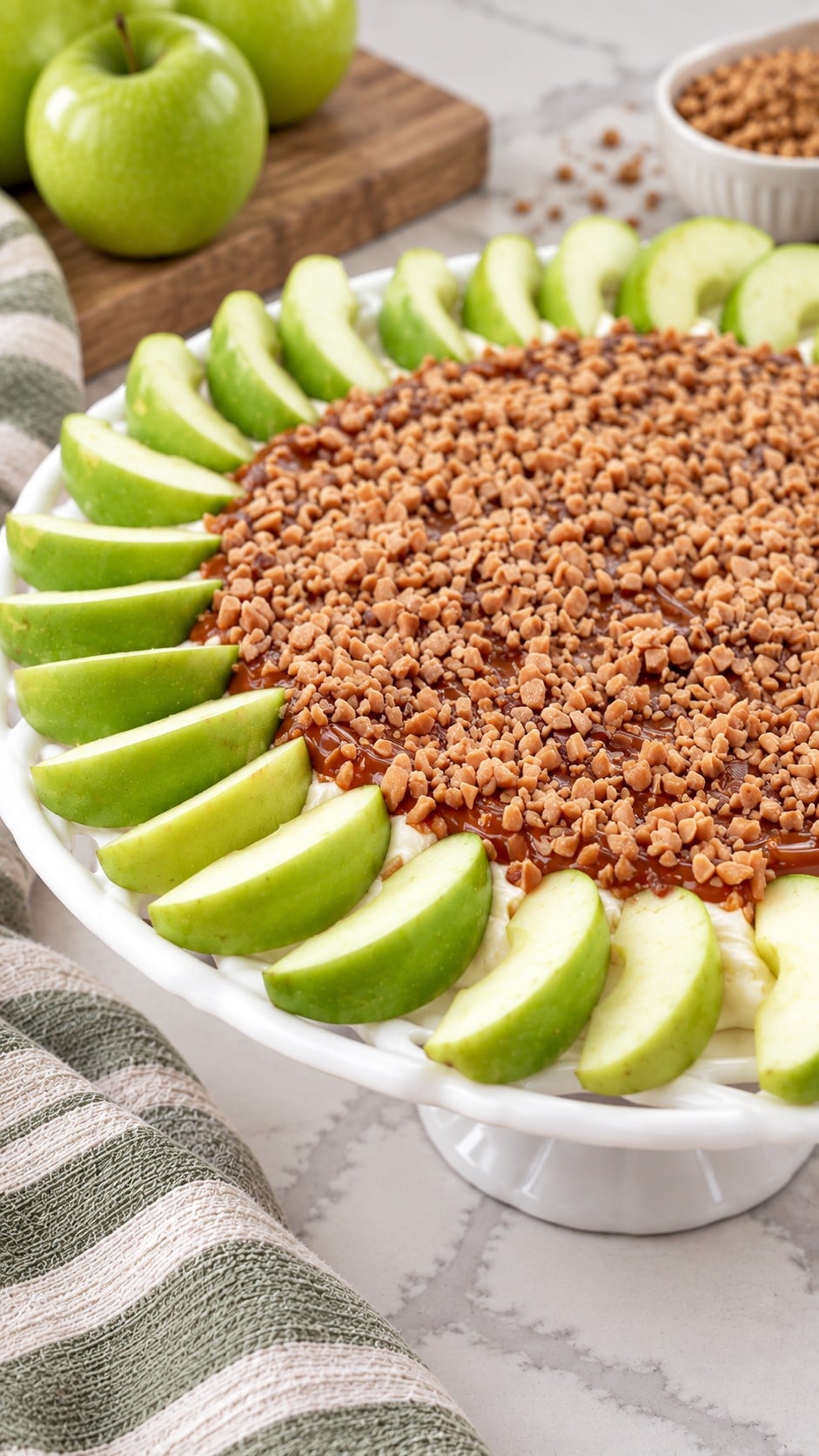 Close view of toffee topping, caramel and cream cheese beside green apple wedges