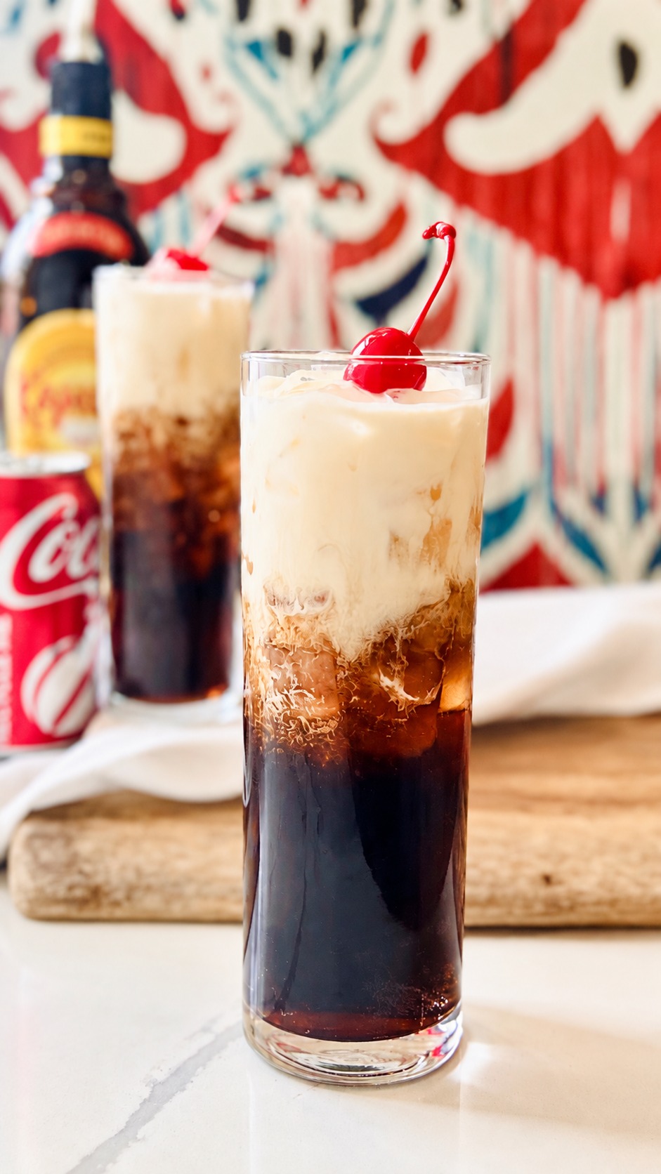 Close view of the separated cream and coffee-cola layers in a cherry-topped Colorado Bulldog highball.