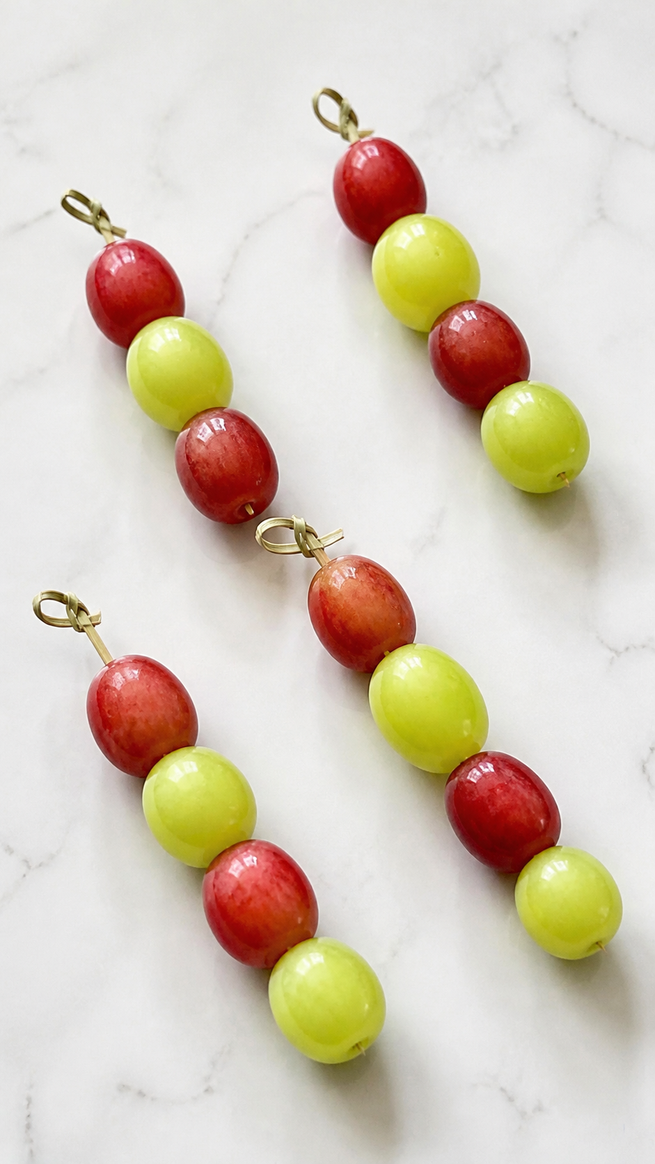Red and green grapes alternated on cocktail skewers for charcuterie cups.