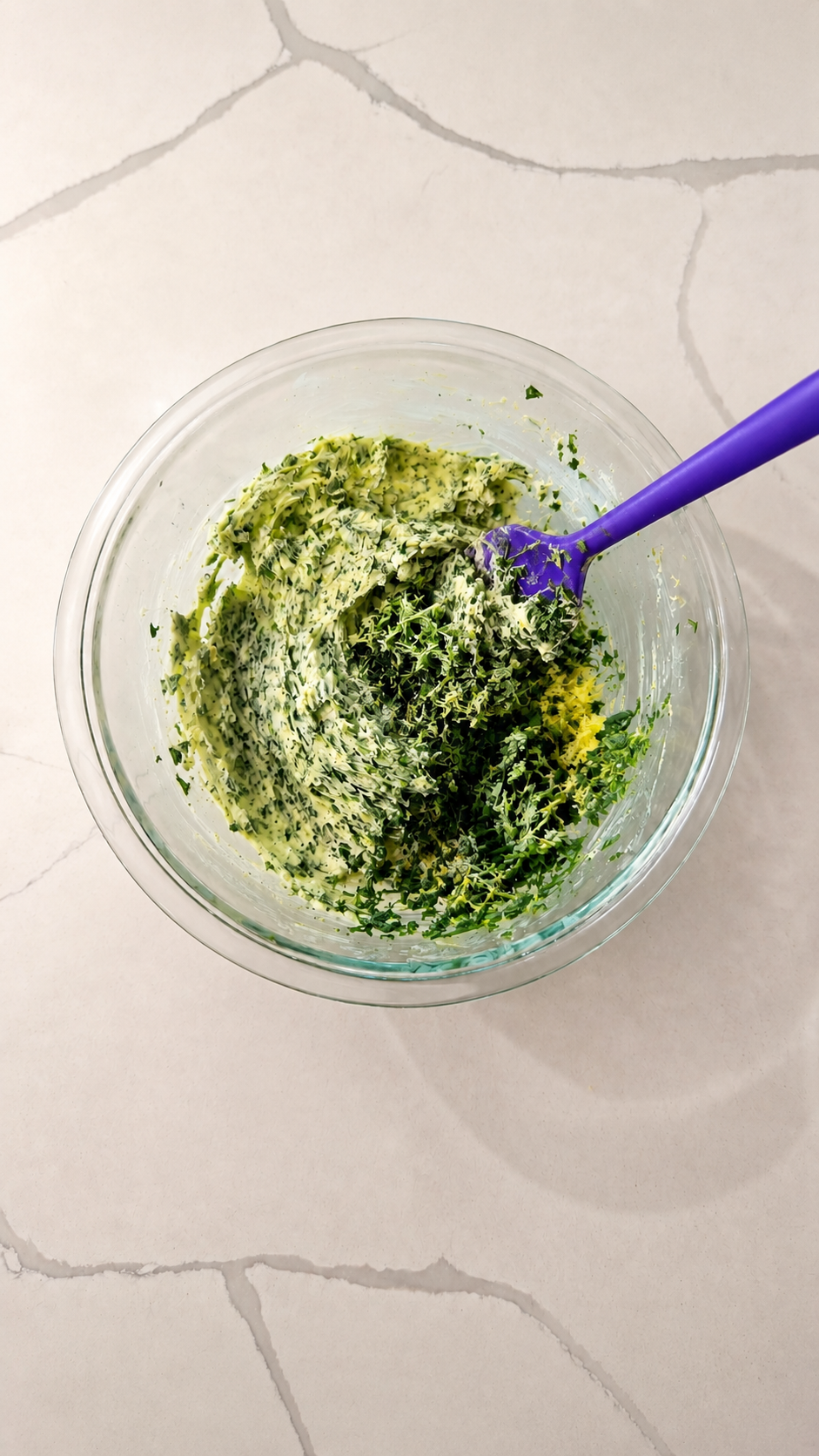 Fresh garlic herb butter mixed with lemon zest in a glass bowl