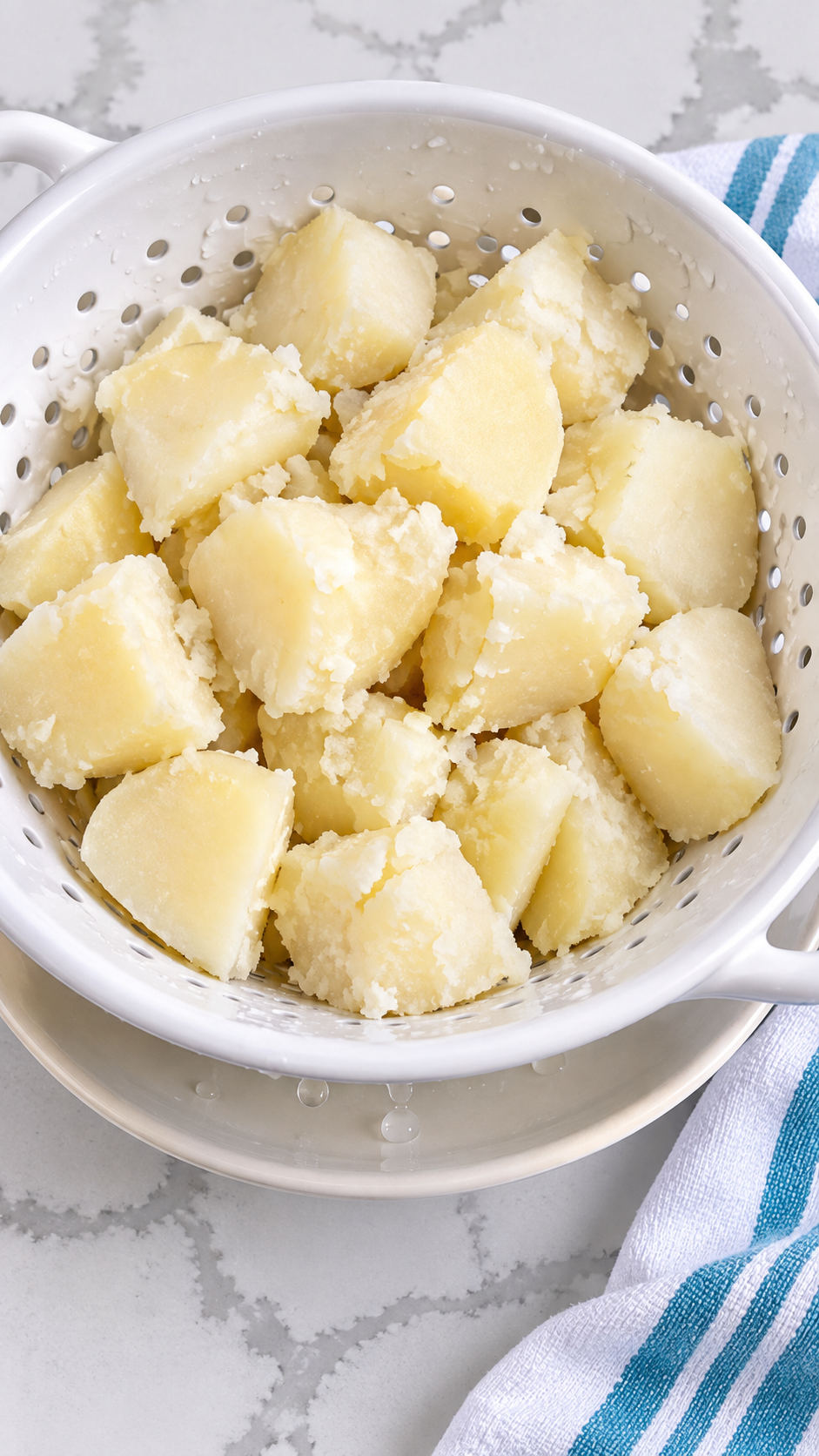 Cooked potato chunks draining in a colander