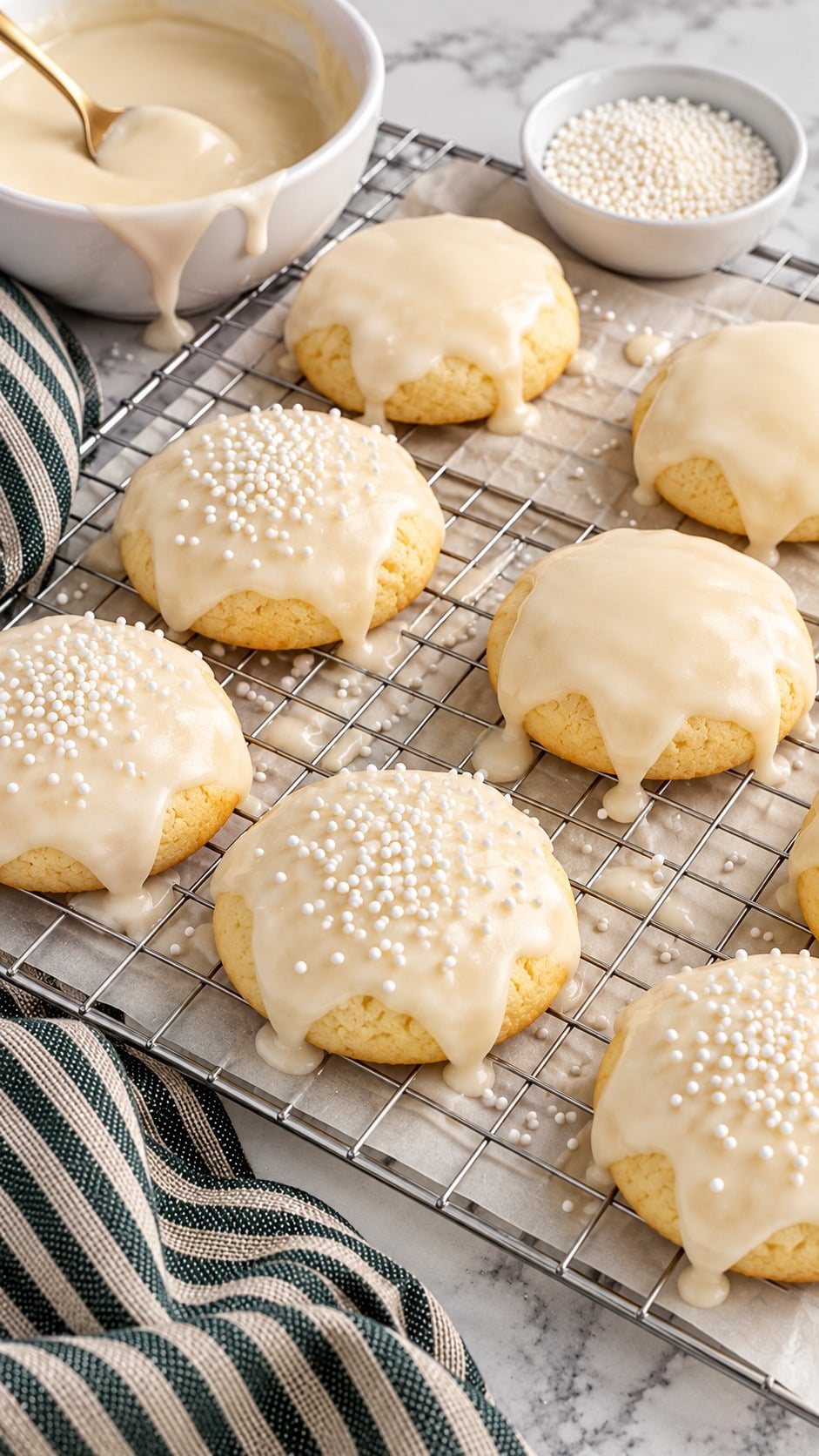 Adding white nonpareils to freshly iced Italian Christmas cookies.