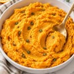 Finished sweet potato mash spooned into a white serving bowl