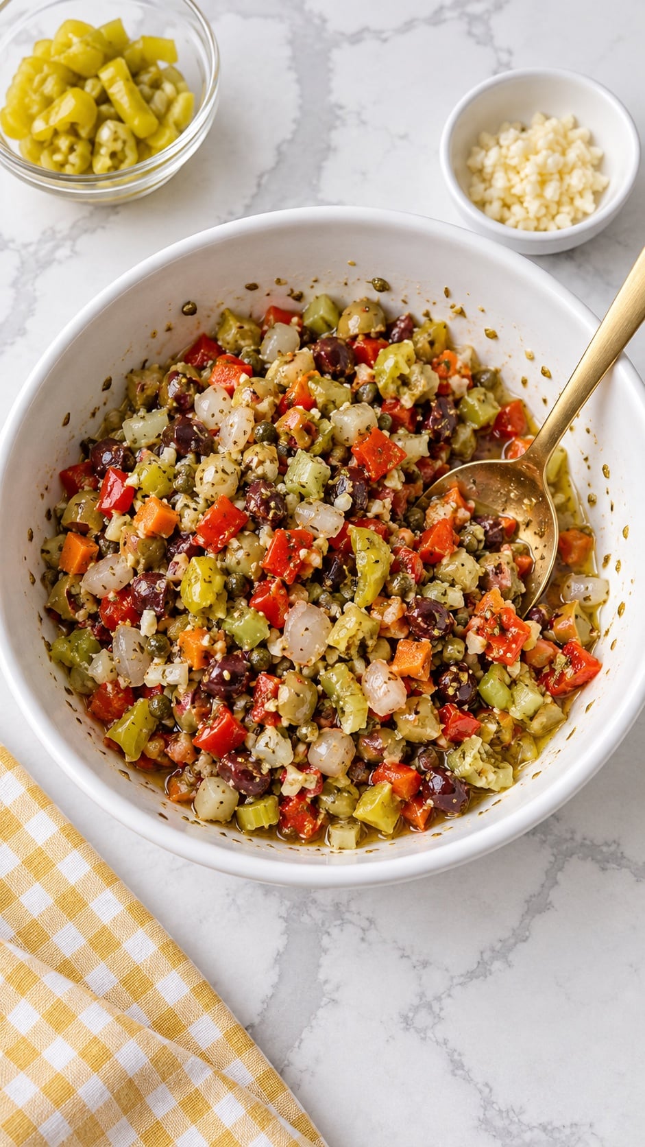 Coarsely chopped olive salad mixed with herbs, oil, and vinegar in a white bowl