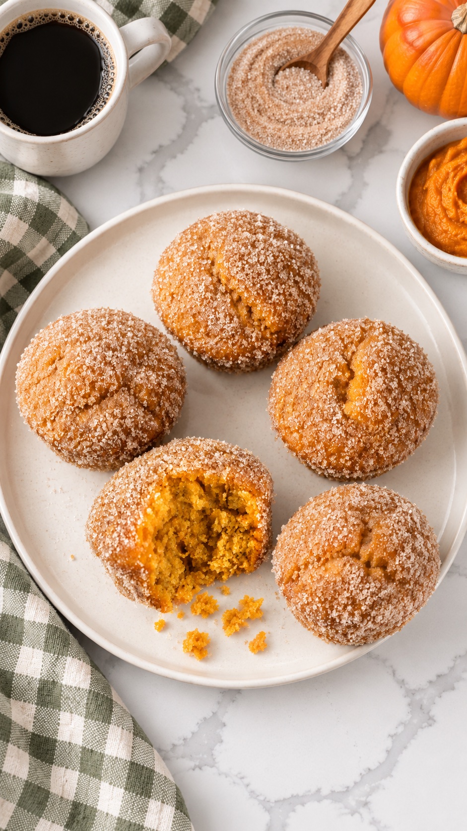Overhead view of cinnamon sugar pumpkin muffins on the same ivory platter