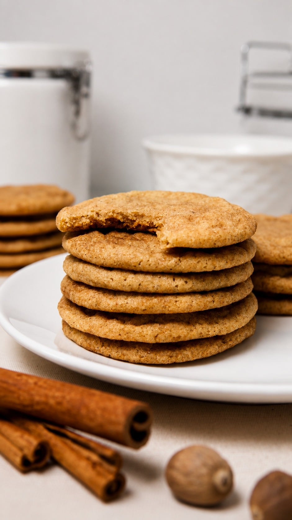 Soft pumpkin spice cookies stacked on a plate with a bitten cookie showing a dense chewy center.