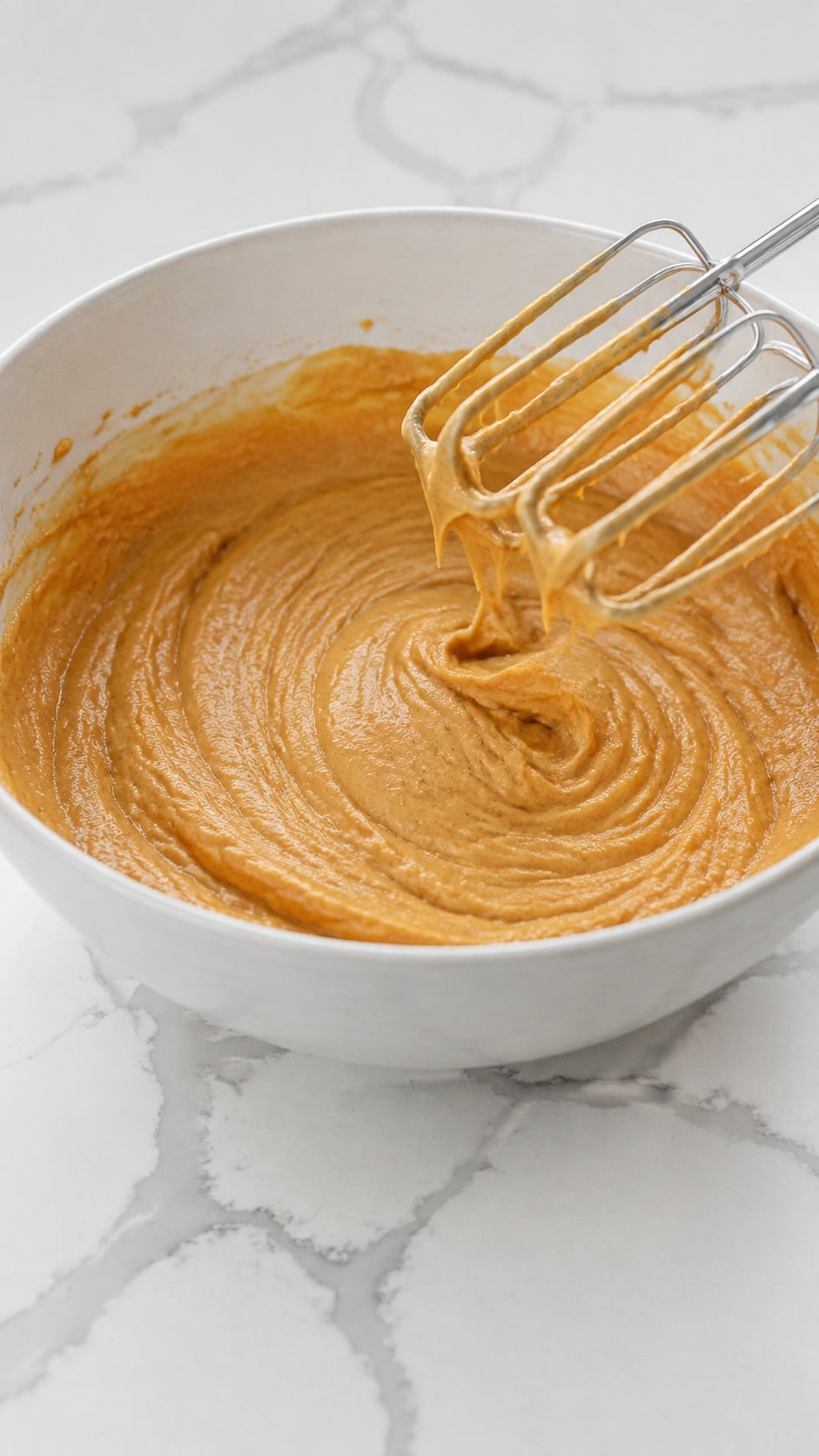 Egg yolks, vanilla bean paste, and concentrated pumpkin mixed into the creamed butter.