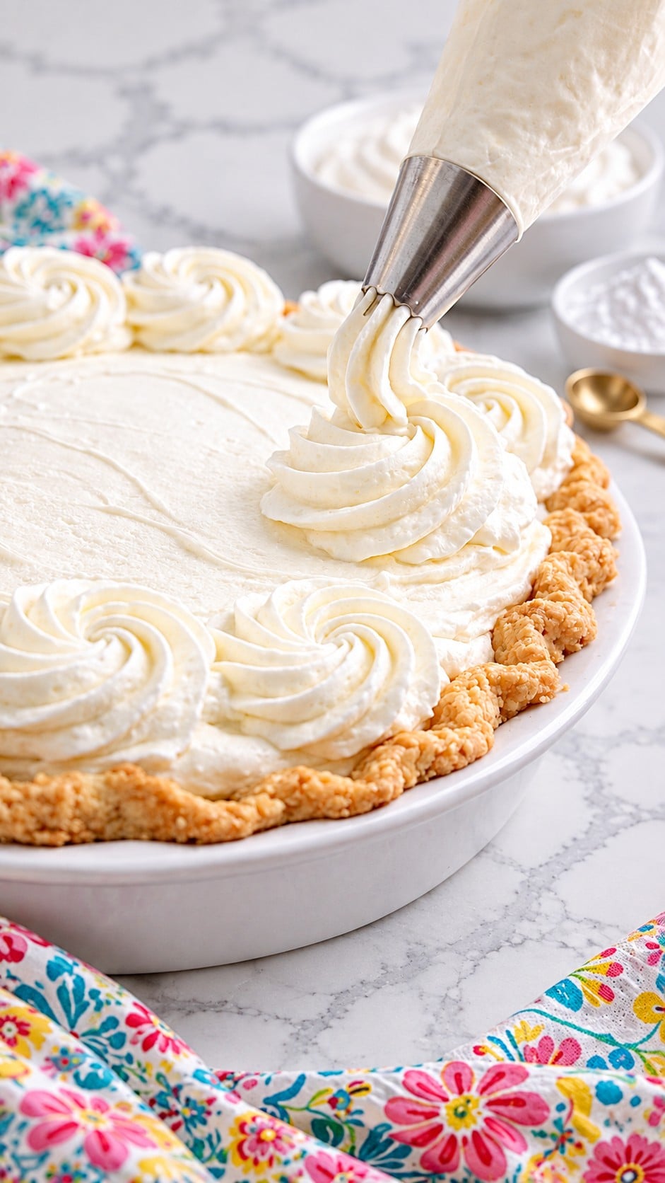 Piping stabilized whipped cream onto a pie with a star tip.