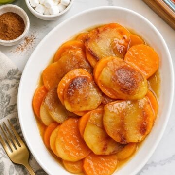 Sweet potato apple bake with tender slices in cinnamon-butter juices on a white plate
