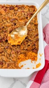 Spoonful of creamy sweet potato casserole with pecan praline topping