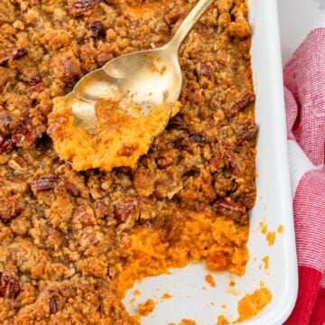 Spoonful of creamy sweet potato casserole with pecan praline topping