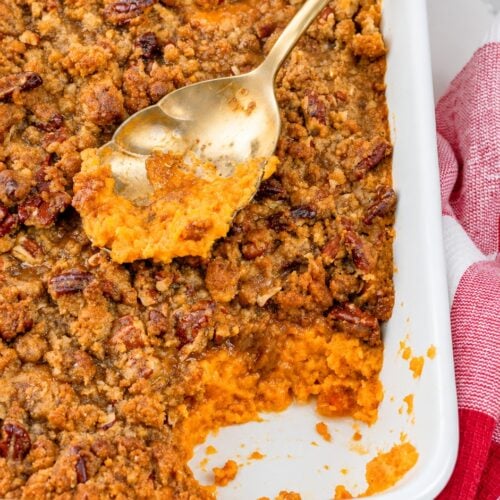 Spoonful of creamy sweet potato casserole with pecan praline topping