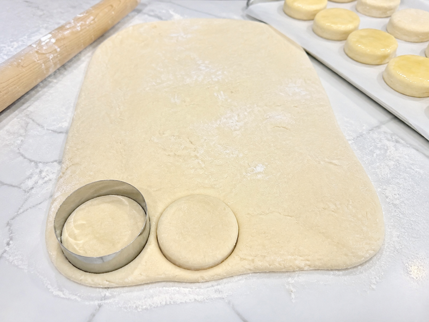 Rolled kolache dough being cut into rounds for shaping