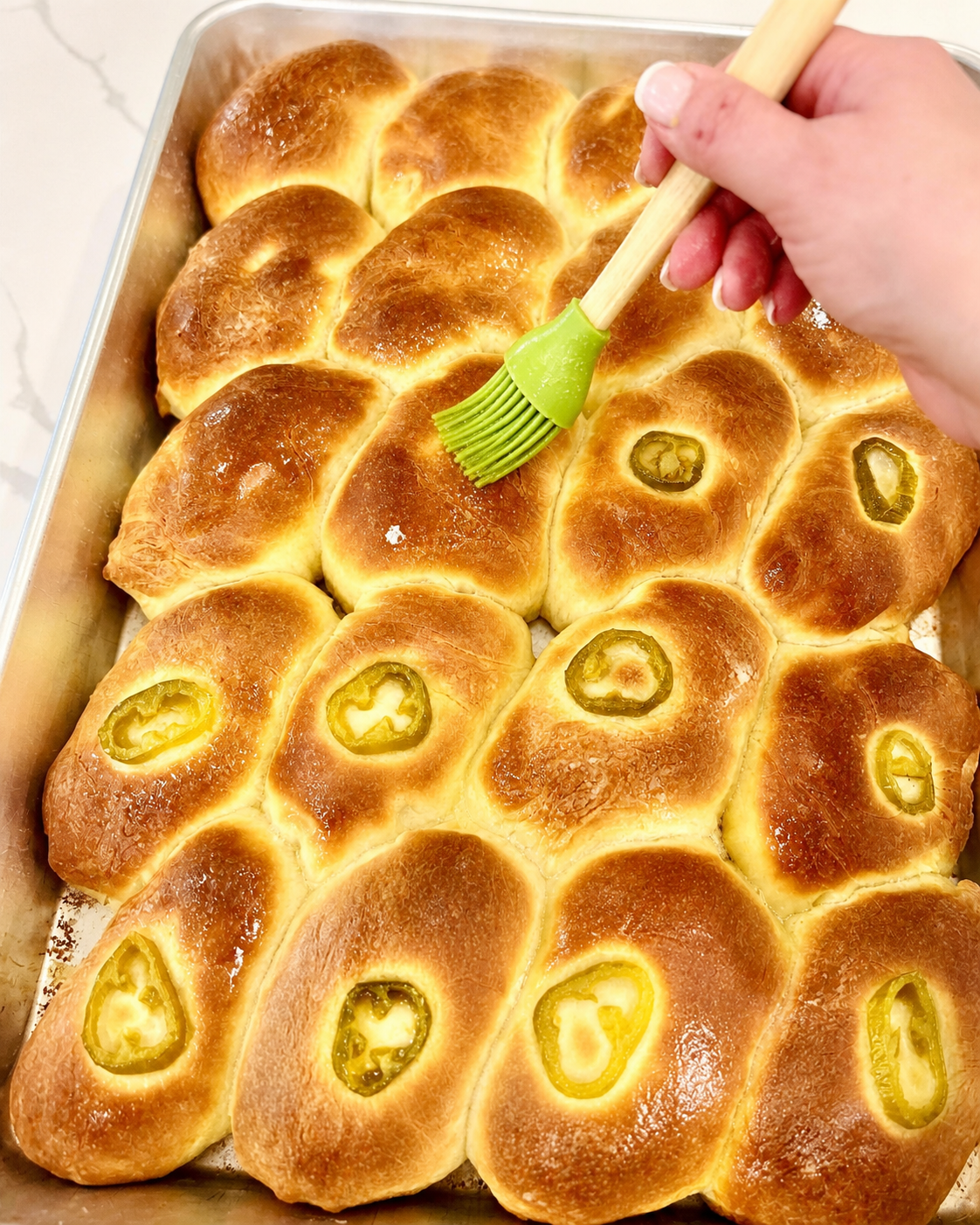 Shaped oblong sausage kolaches arranged seam-side down before baking