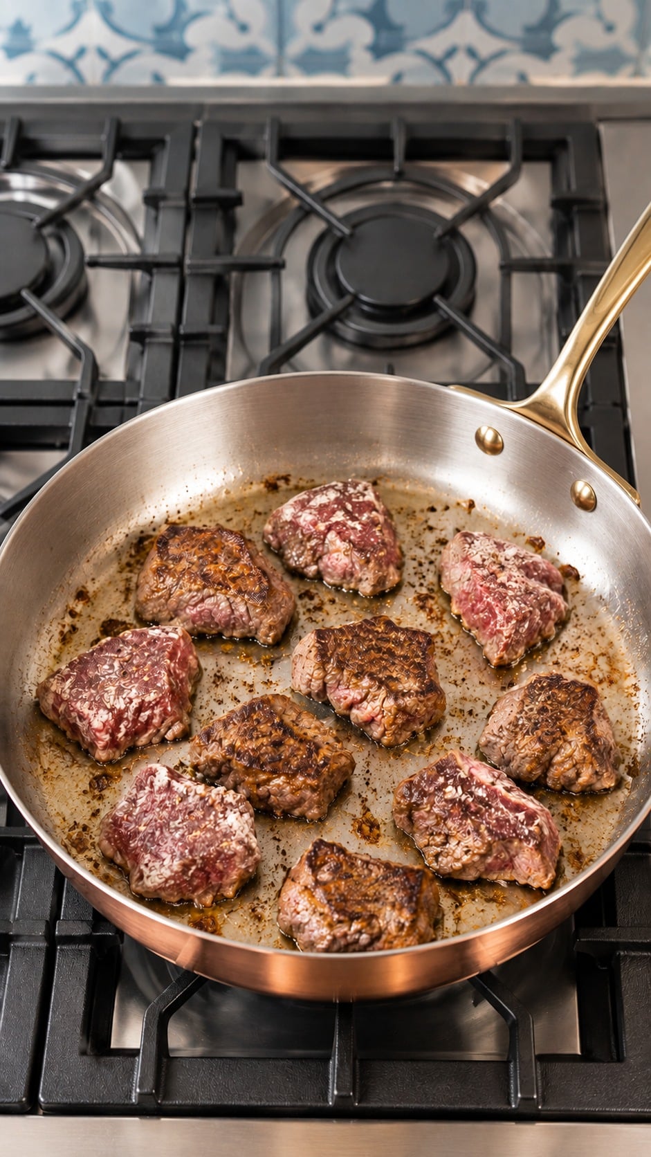 Sirloin pieces browning in an uncrowded batch in a sauté pan.