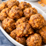 Bisquick sausage balls on a handled white oval platter with honey mustard.