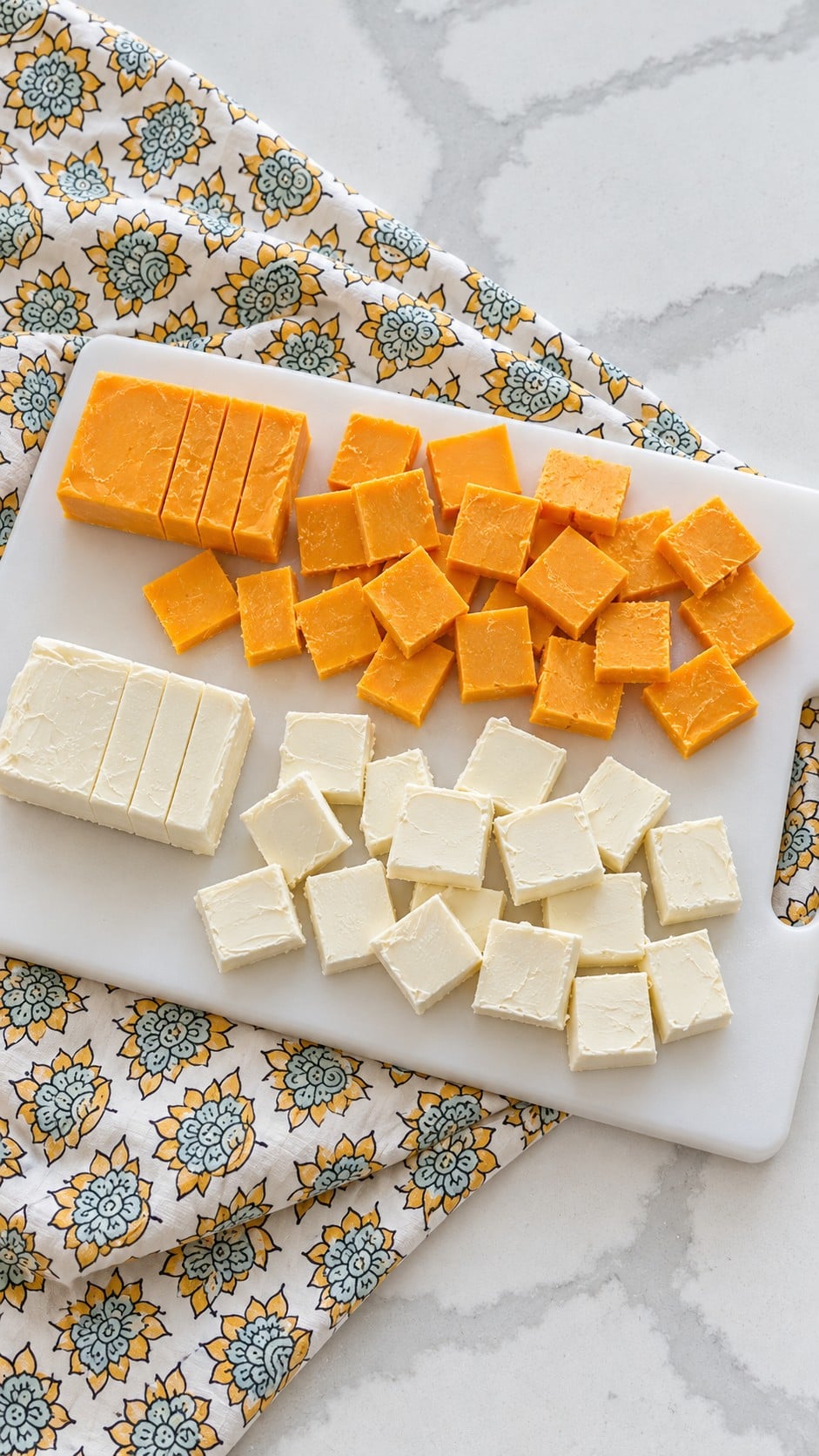 Small hand-cut cheddar and cream cheese slices ready to arrange.