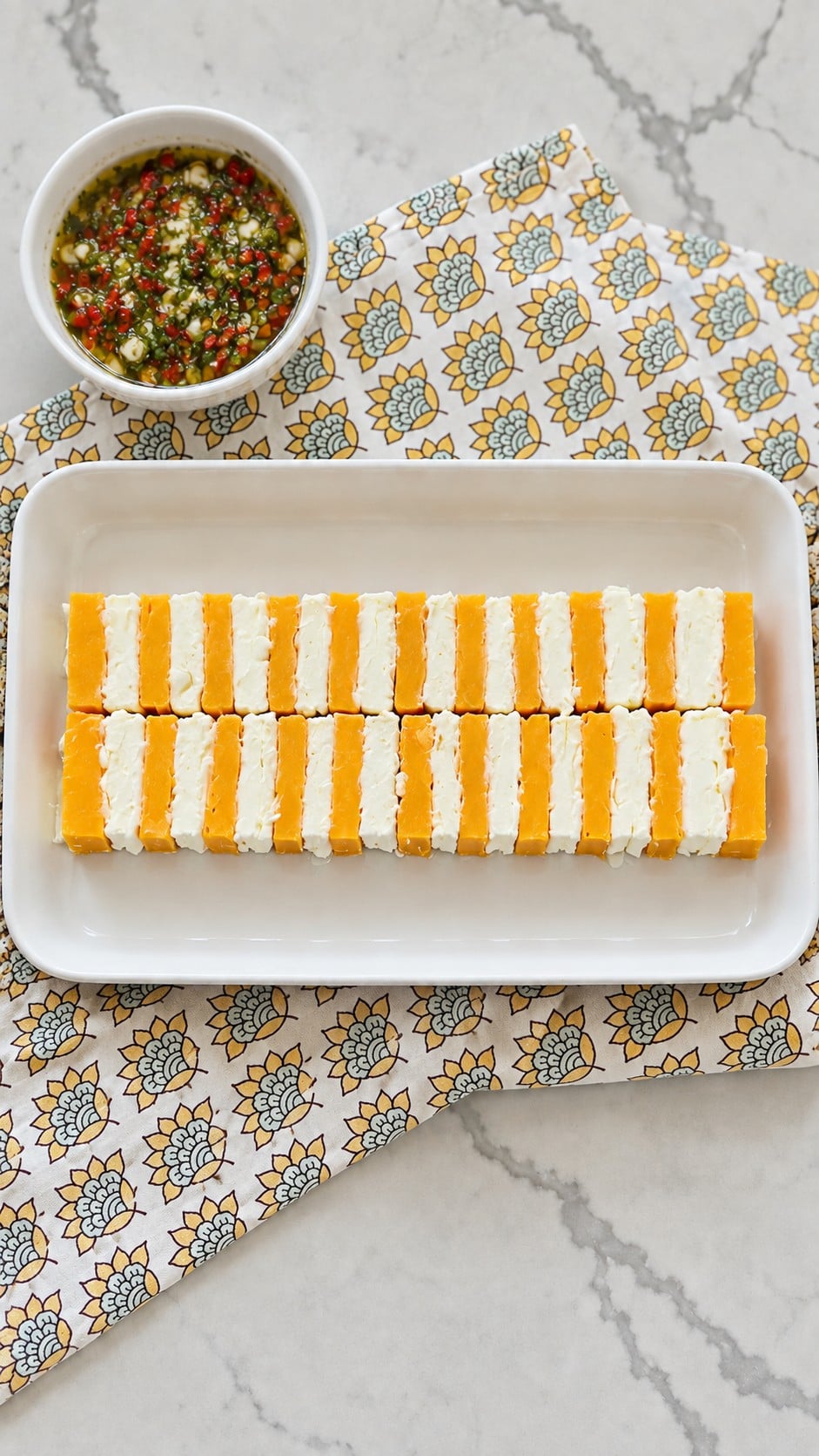 Two touching rows of upright alternating cheddar and cream cheese slices before adding marinade.
