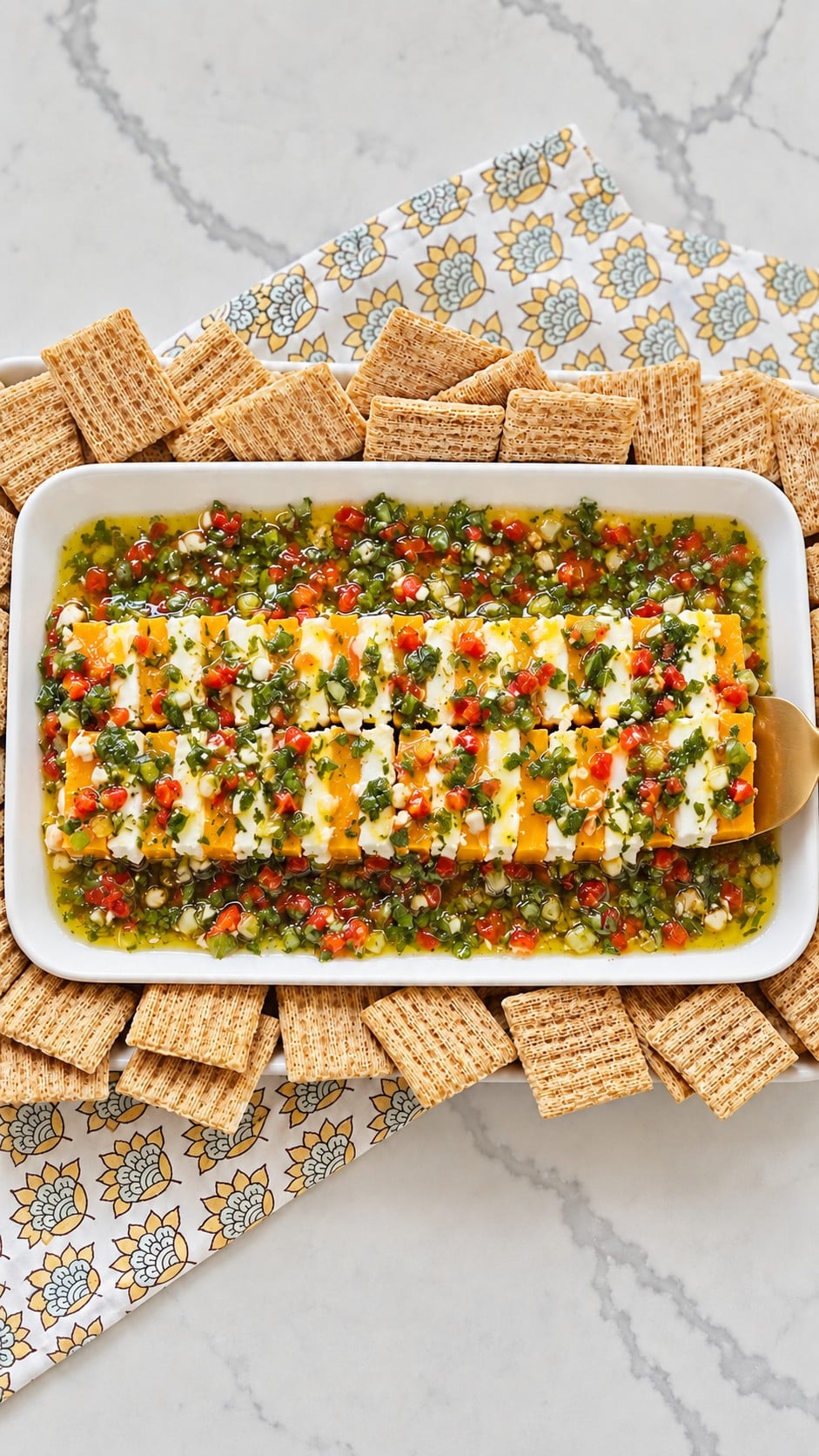A wide spatula lifting a section of alternating marinated cheese slices.