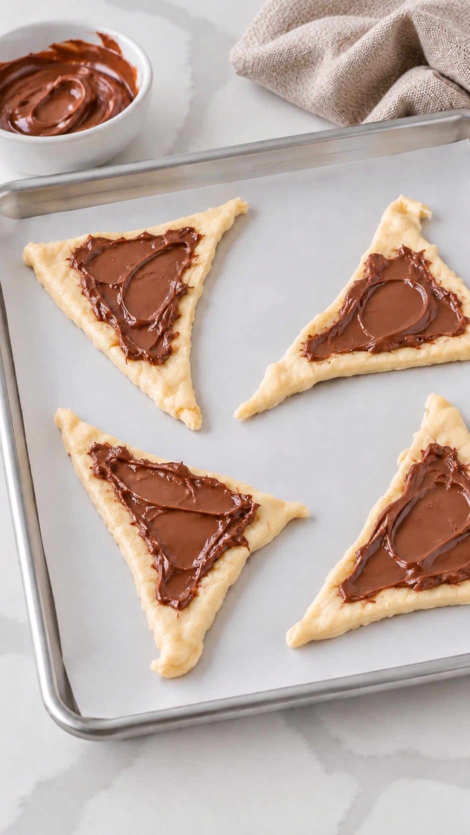 Raw crescent triangles spread with Nutella, leaving a narrow border