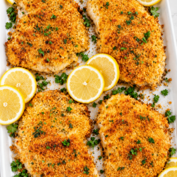 Baked Parmesan crusted tilapia with golden panko and lemon on a white handled platter